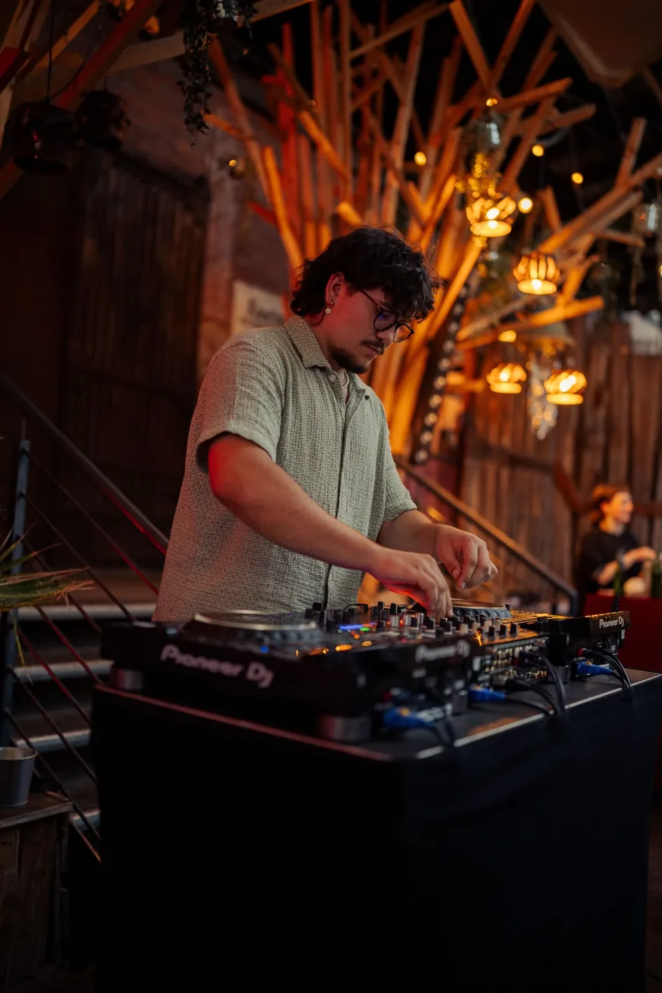 Flo beim Auflegen am DJ-Pult in einer warm beleuchteten Location